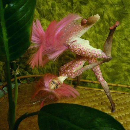 Fuchsia, a centauroid dancer with flowers dyed into her pelt, on a raft in a stylized swamp in the Loiba Islands on Kakalea, a dry world. Click to enlarge.