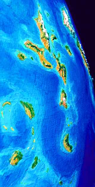 Orbital photo of golden islands- (drygrass prairies) and a snowy range rising from the sea on the horizon. The Shielding Islands and Scania, on Lyr, a model of a huge sea-world. Click to enlarge.